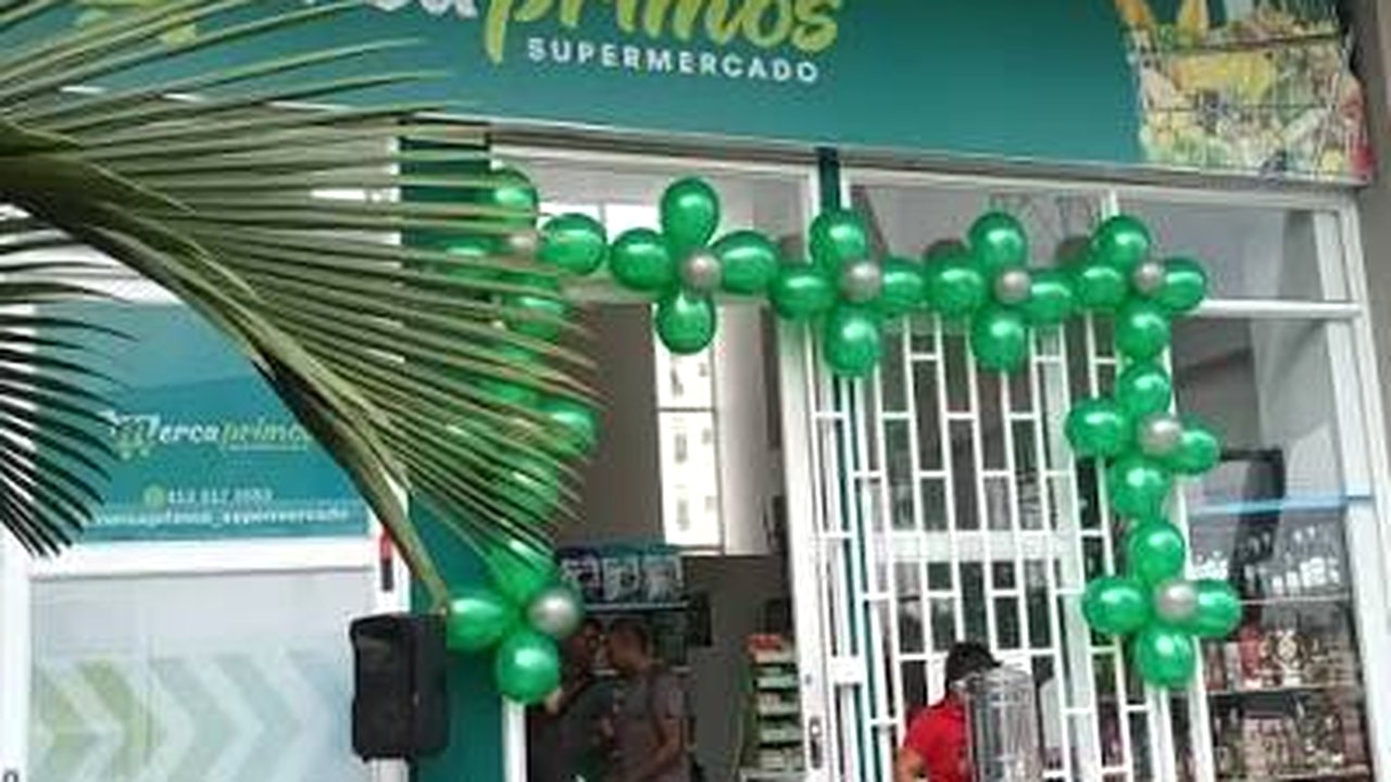 Entrada de Mercaprimos decorada para su aniversario con globos verdes
